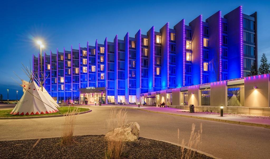 ein großes Gebäude bei Nacht mit einem Gebäude in der Unterkunft Grey Eagle Resort in Calgary