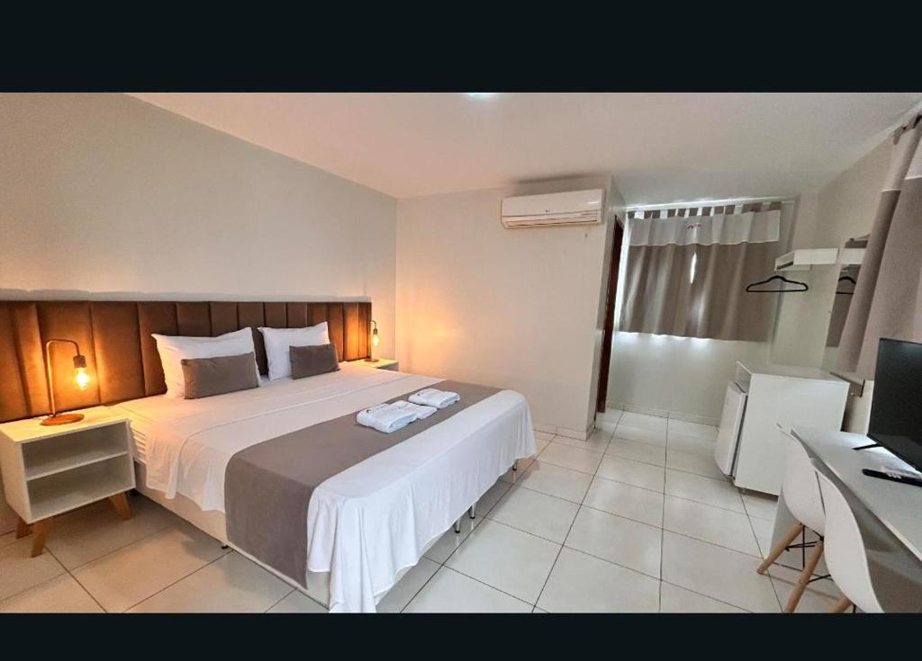 a bedroom with a bed and a desk with a computer at Rio Hotel in Petrolândia