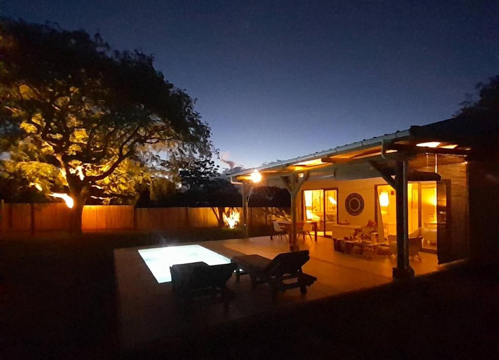 a patio with a table and chairs at night at Chamallow Nature Lodge in Grande Case Noyale