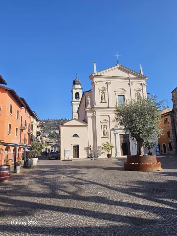 a large white building with a clock tower on a street at Appartamento Torri del Benaco in Torri del Benaco