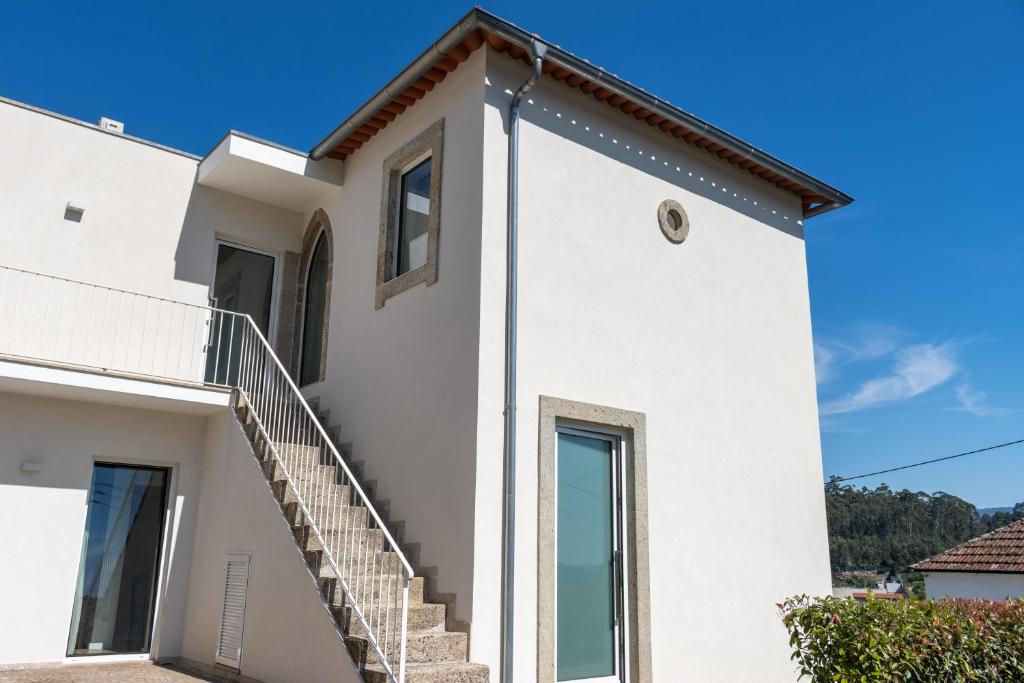 a white house with a staircase at Casa de Algeriz in Algeriz