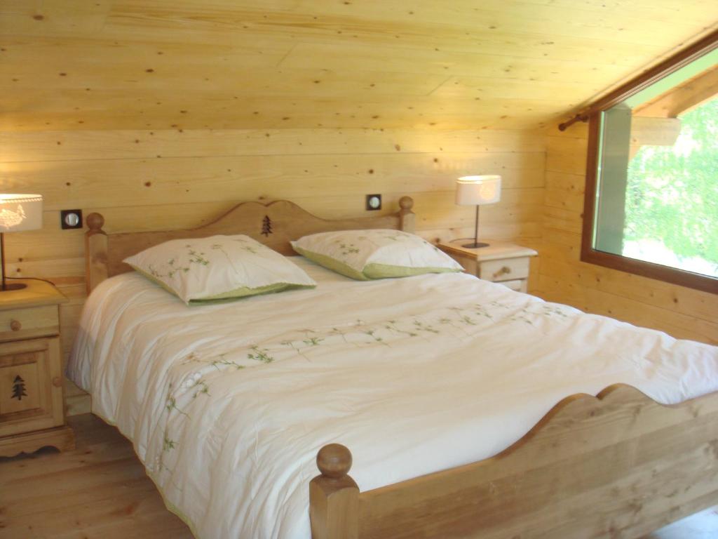 um quarto com uma cama num chalé de madeira em Chalet Elisa em Le Valtin