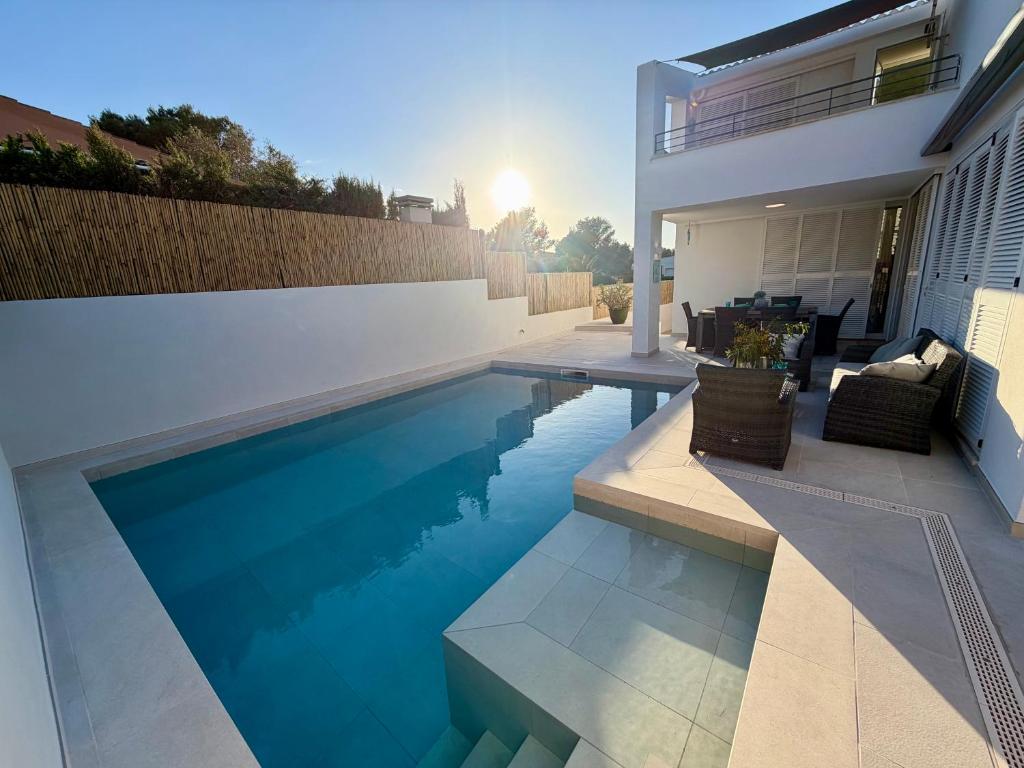 a swimming pool in front of a house at Villa BEACH&OCEAN in Son Serra de Marina