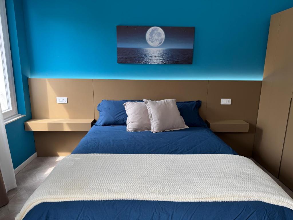a bedroom with a bed with a blue wall at HOUSE on sunday LUNA in Crotone