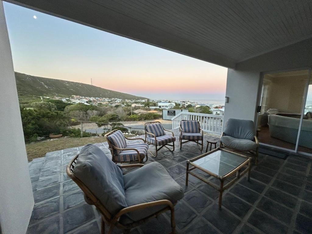 a patio with chairs and a table on a balcony at Restio in Agulhas