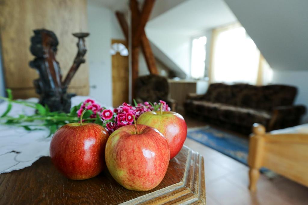 three apples sitting on a table in a living room at Aktywna Agroturystyka in Stare Jabłonki