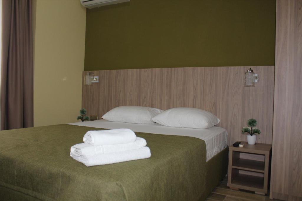 a bedroom with a bed with towels on it at Hotel Vega in Krasnodar