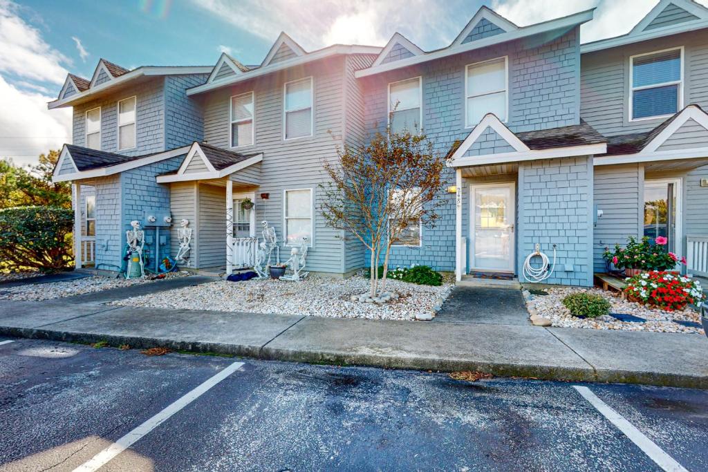 a house with a parking lot in front of it at Maxs Nautical Nook Village OBX in Kitty Hawk