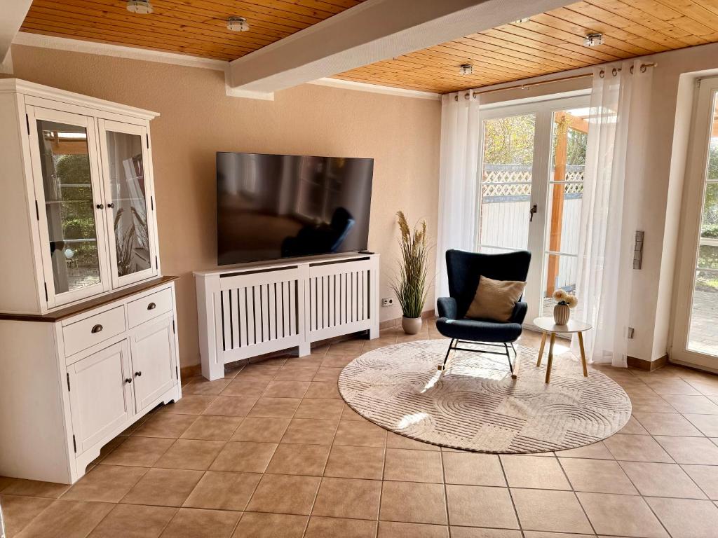 a living room with a tv and a chair at Ferienhaus Schlummerkoje in Friedrichskoog