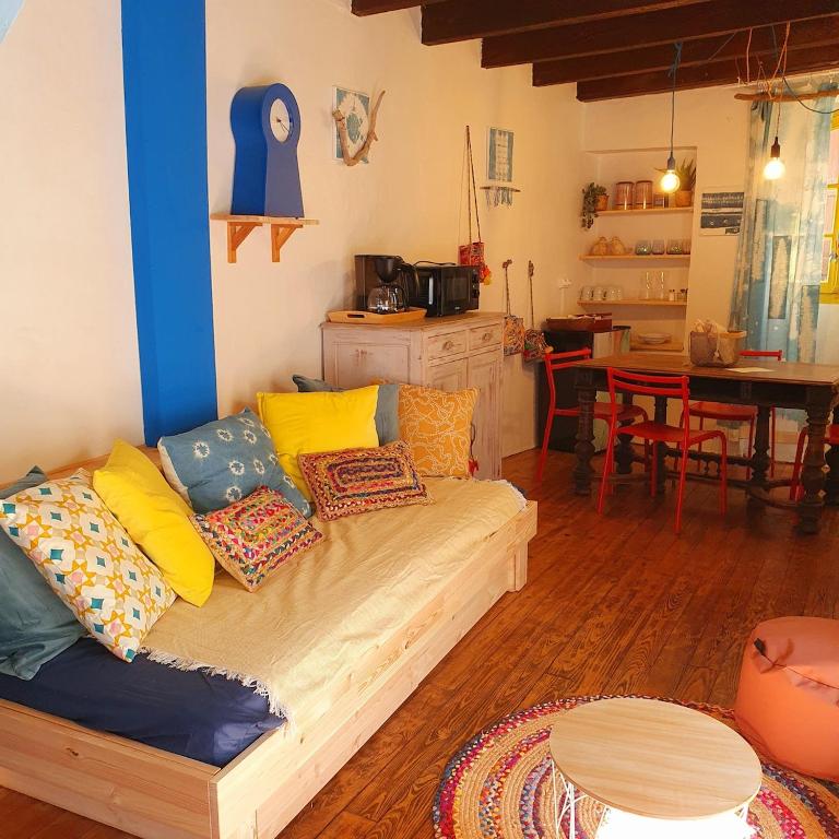 a living room with a couch with colorful pillows at Gîte à Florac "Les Rêves Bleus" in La Salle-Prunet