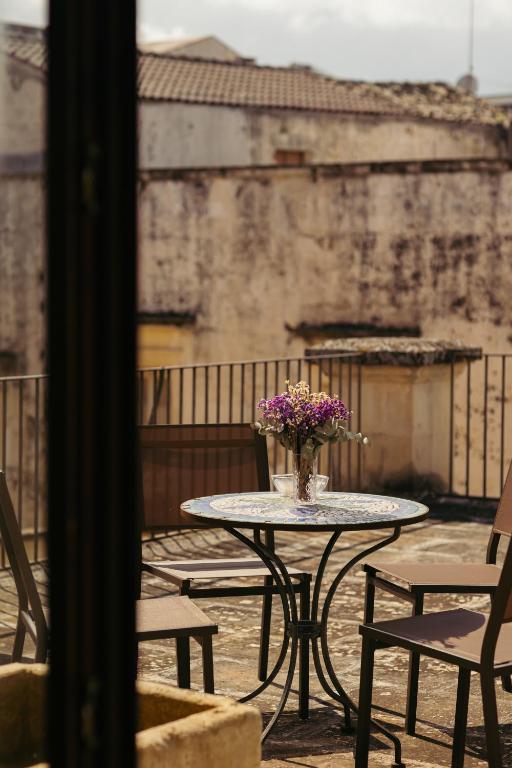 a table with a vase of flowers on a balcony at Blu Rooms in Galatina
