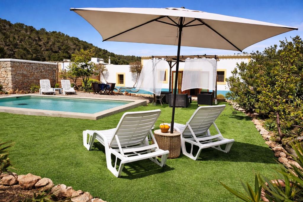 two chairs and an umbrella next to a pool at Can Pep Pardal in Sant Miquel de Balansat