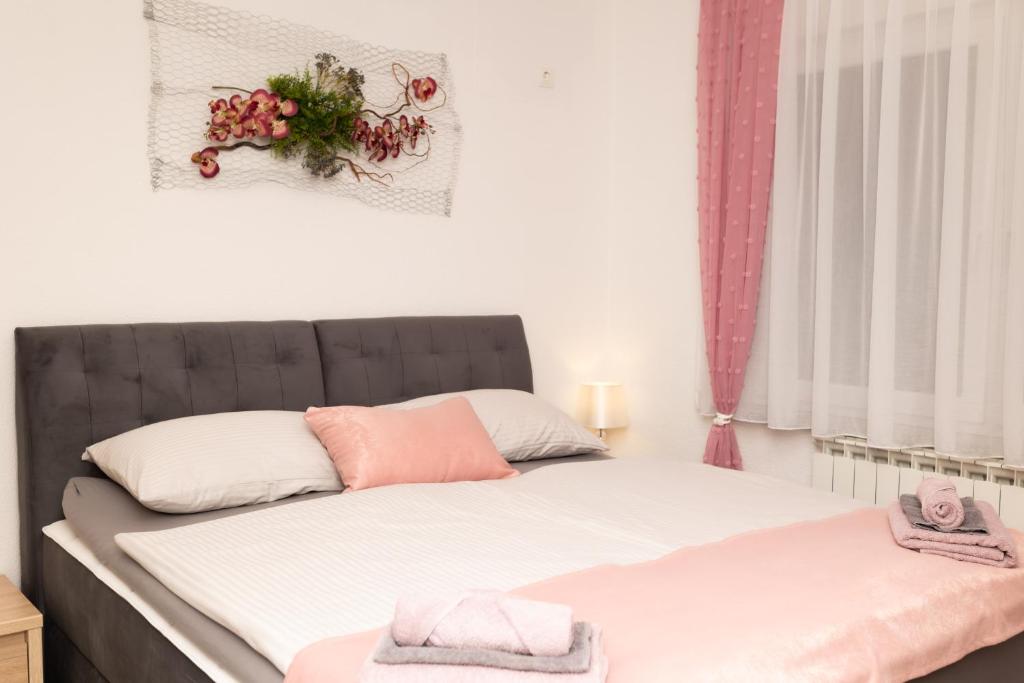 a bedroom with two beds with pink towels on them at Apartman Orhideja in Gospić