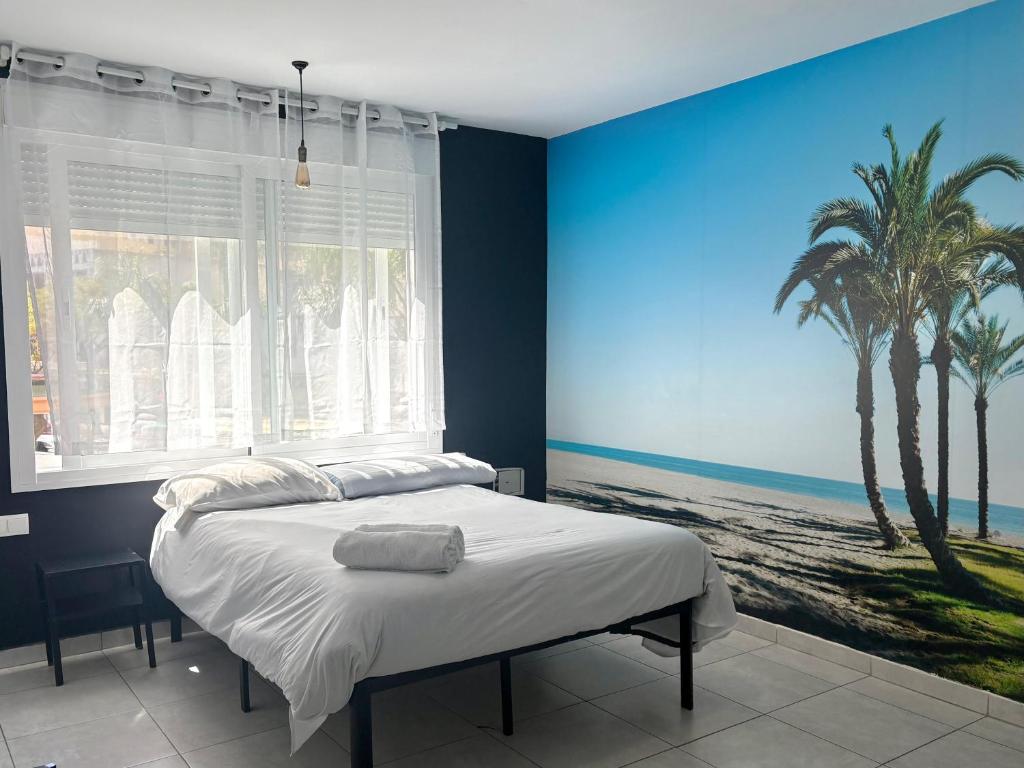 a bedroom with a bed with a painting of a palm tree at SolRoom (plz. La Nogalera) in Torremolinos