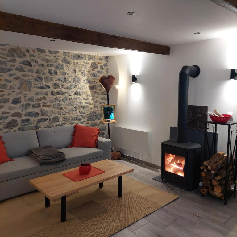 a living room with a couch and a wood stove at La petite Maison in Fromelennes