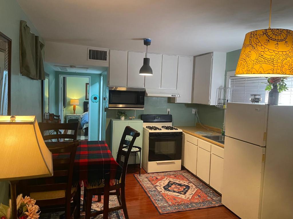 a kitchen with white cabinets and a table and a dining room at BACK HOUSE in PASADENA in Pasadena