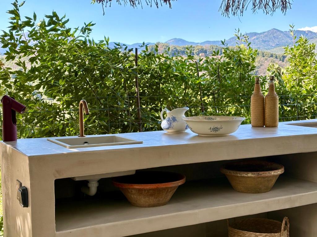 a kitchen counter with a sink and bowls on it at Housica & Co. in Ucciani
