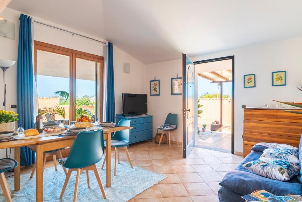 a living room with a table and chairs and a couch at Ri Ale Sa prassa Sardegna Ogliastra in Bari Sardo