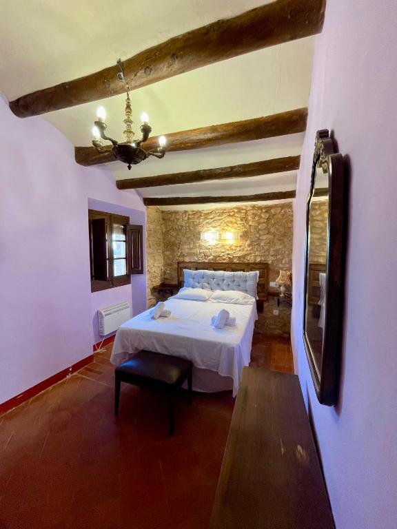 a bedroom with a white bed and a mirror at Cal Isabel in Pobla de Montornés