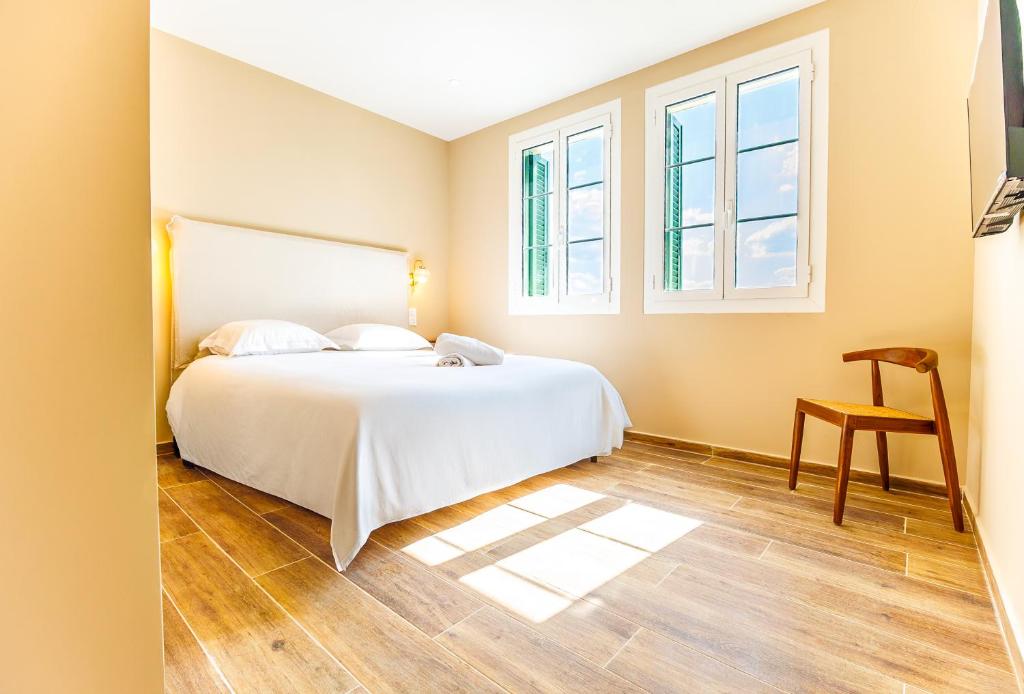 a bedroom with a bed and a chair and windows at Juliette in Venaco