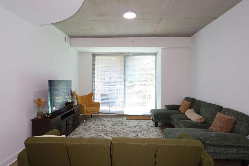 a living room with a couch and a tv at Luxurious Midtown Apartment w Sky Lounge & Pool in Atlanta