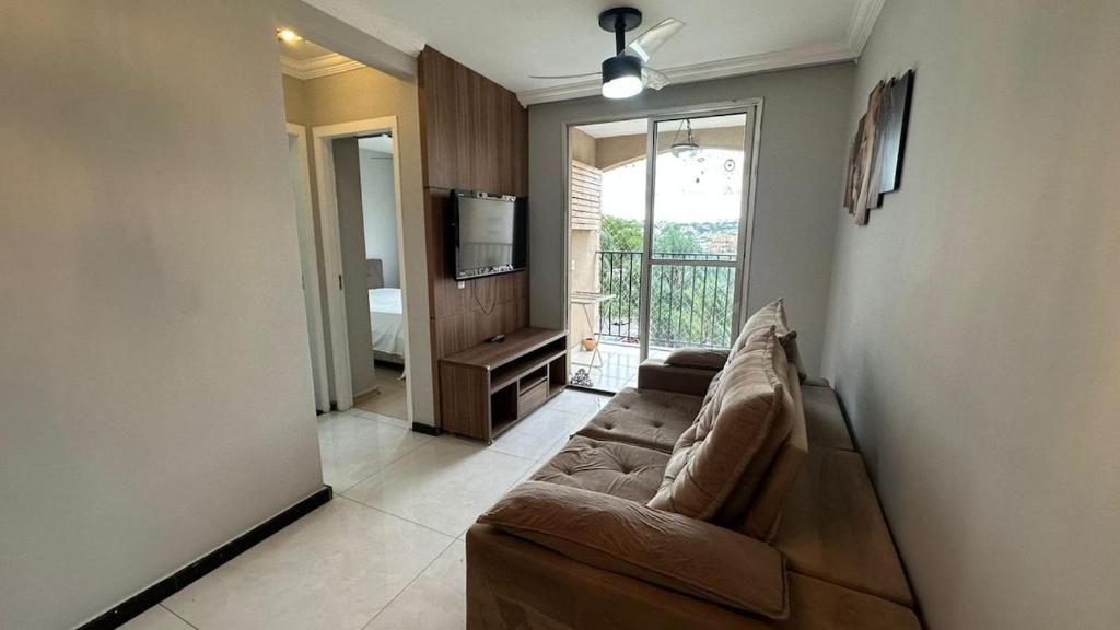 a living room with a couch and a television at Apartamento completo no Planalto in Belo Horizonte