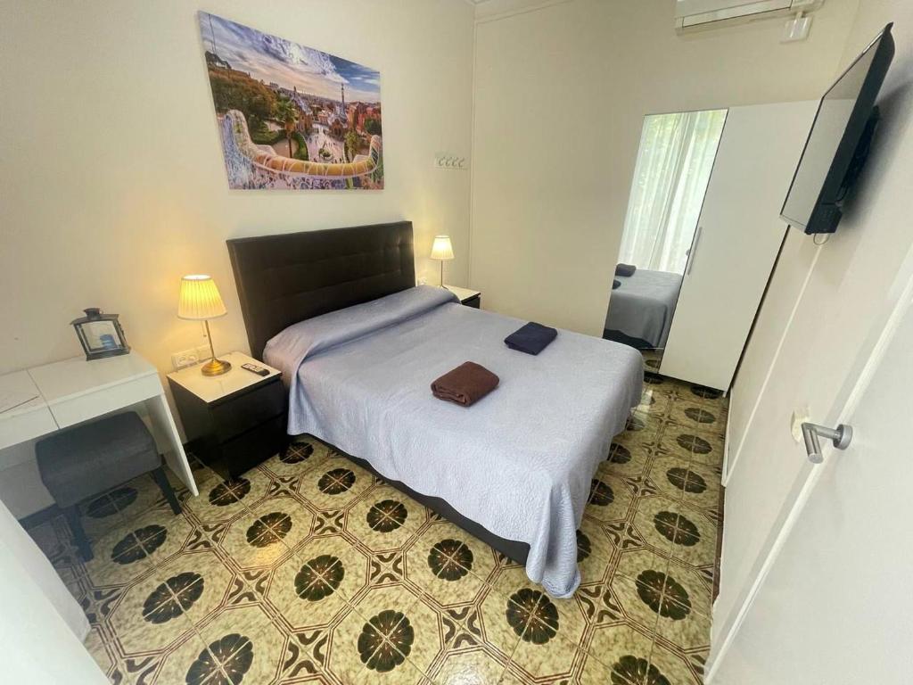 a bedroom with a bed and a desk and a television at Rooms Diputacion in Barcelona