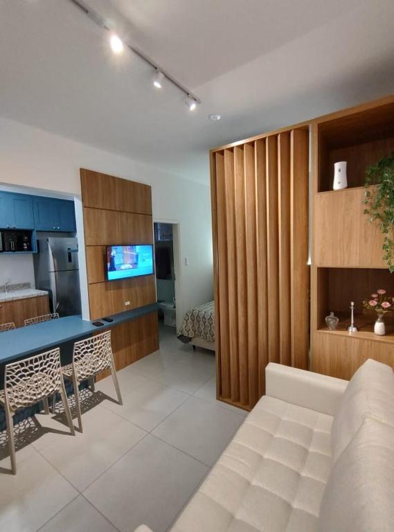 a living room with a couch and a table and a kitchen at House Brigadeiro in Juiz de Fora