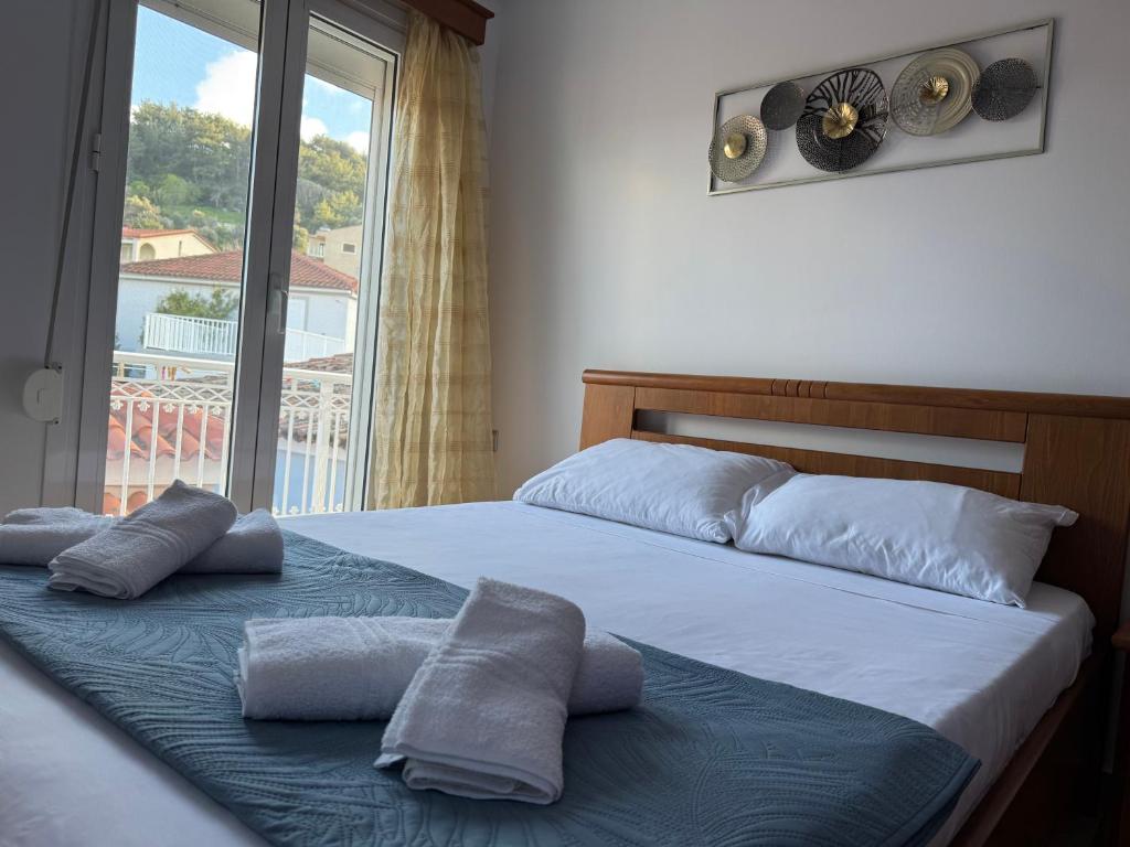 a bedroom with a bed with two pillows and a window at Leka Village Our Hidden Gem in Léka