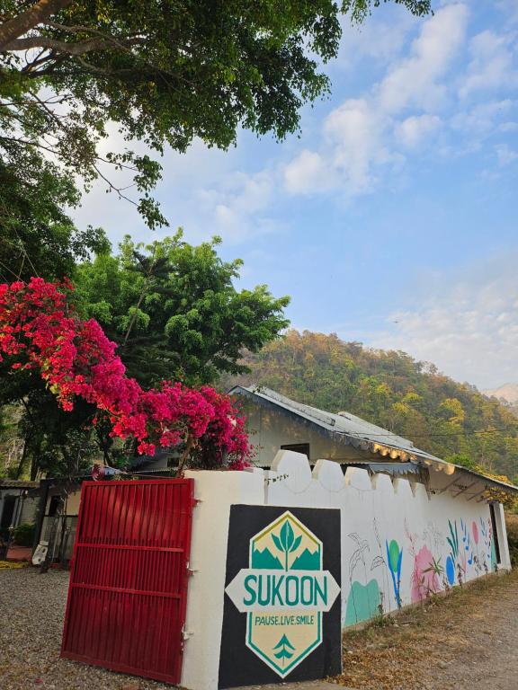 a sign on the side of a building with flowers at Sukoon in Nainital