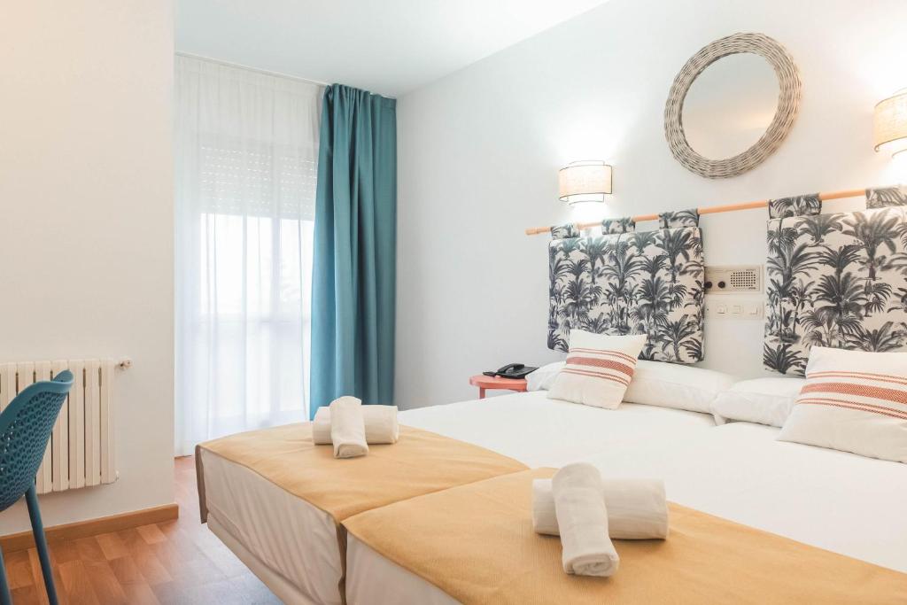 un dormitorio con una cama grande con toallas encima en BLUESEA Costa Norte - Ex MD La Lanzada, en A Lanzada
