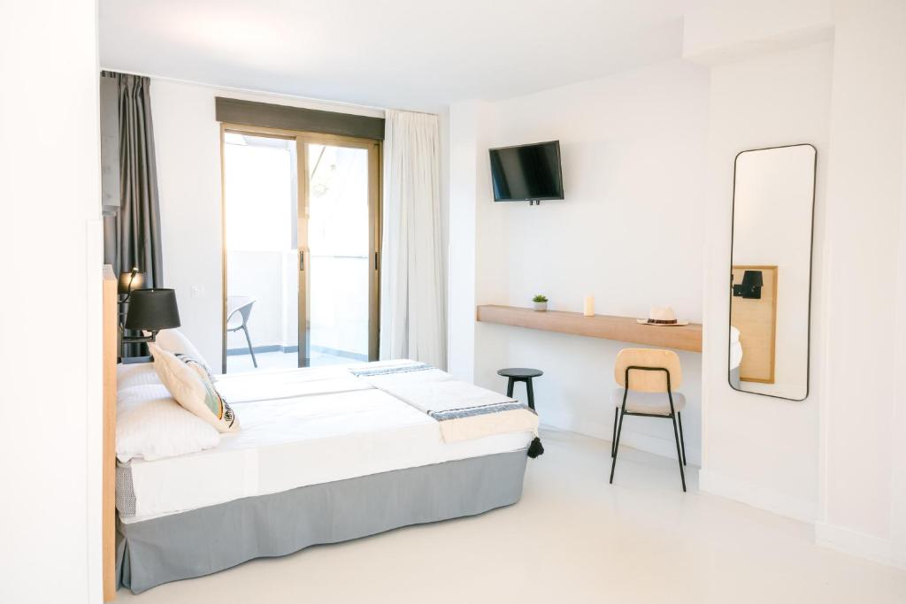 un dormitorio blanco con una cama y un espejo en BLUESEA Faro Cullera, en Cullera