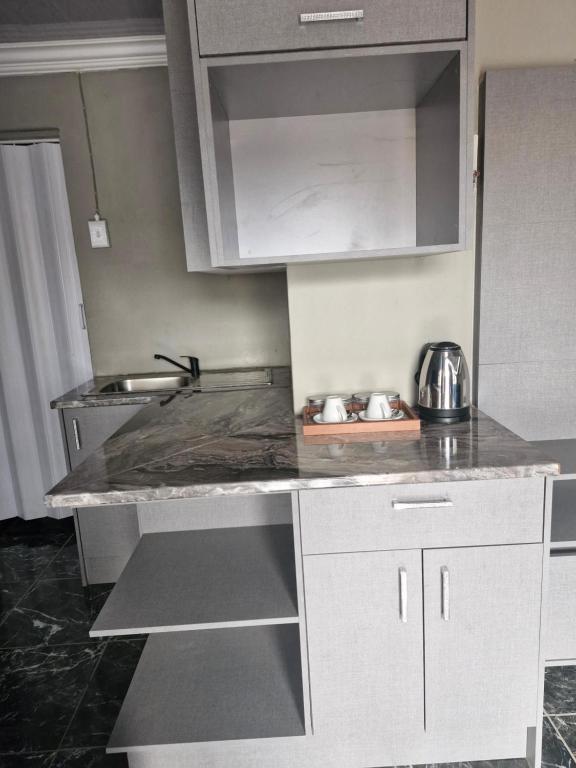 a kitchen with a sink and a counter top at Mams Cozy Guest house in Seshego
