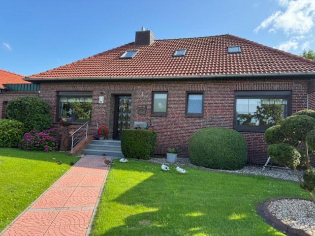 a red brick house with a grass yard at Upkammer im Park in Werdum