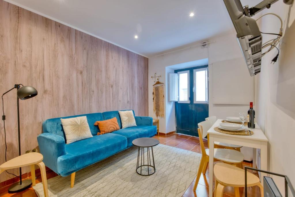 a living room with a blue couch and a table at Bairro Alto Cozy apartment in Lisbon