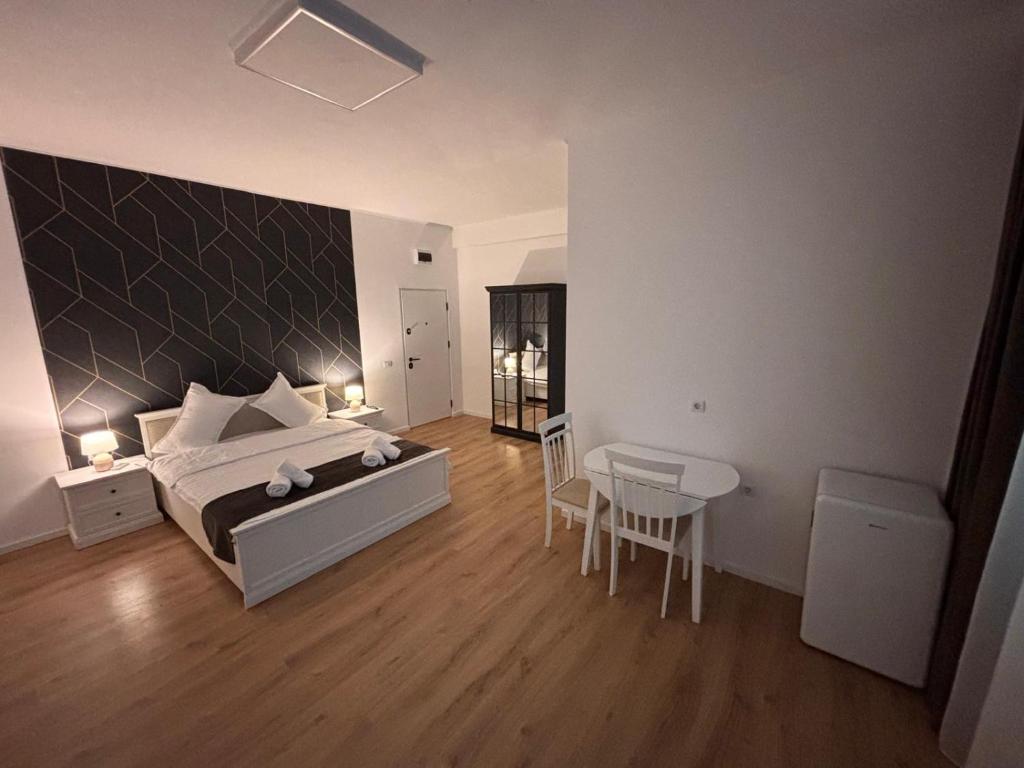 a bedroom with a bed and a table and chairs at Stadium Side Rooms in Craiova