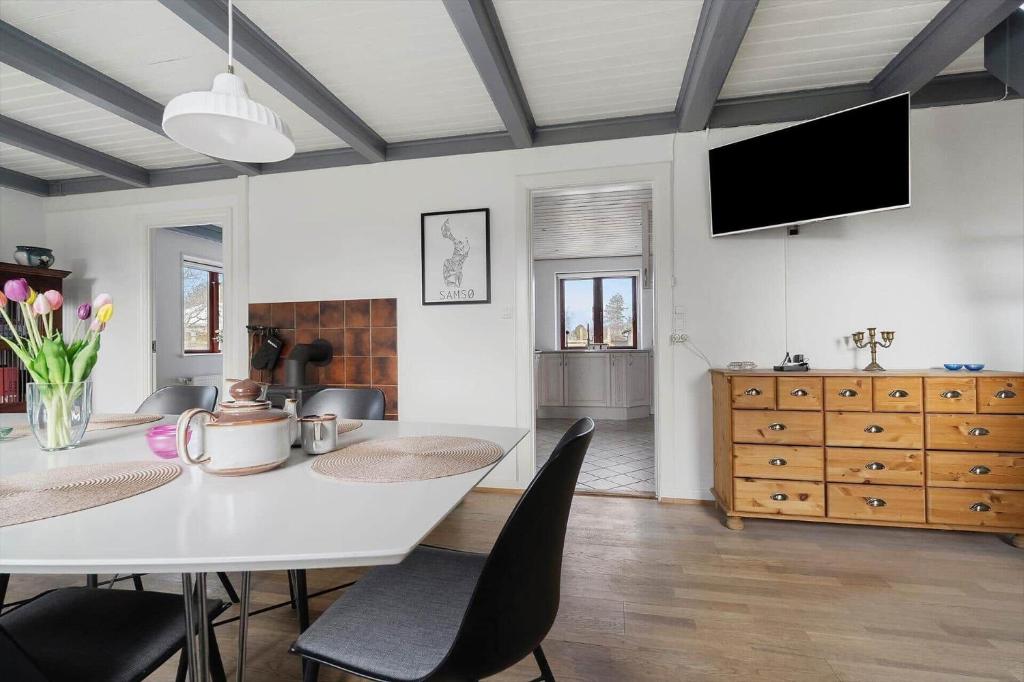 a dining room with a white table and chairs at 20333-Samso-Havvejen-61 in Sælvig