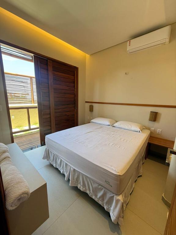 a bedroom with a large bed and a window at Casa Floratta - Flecheiras in Flecheiras