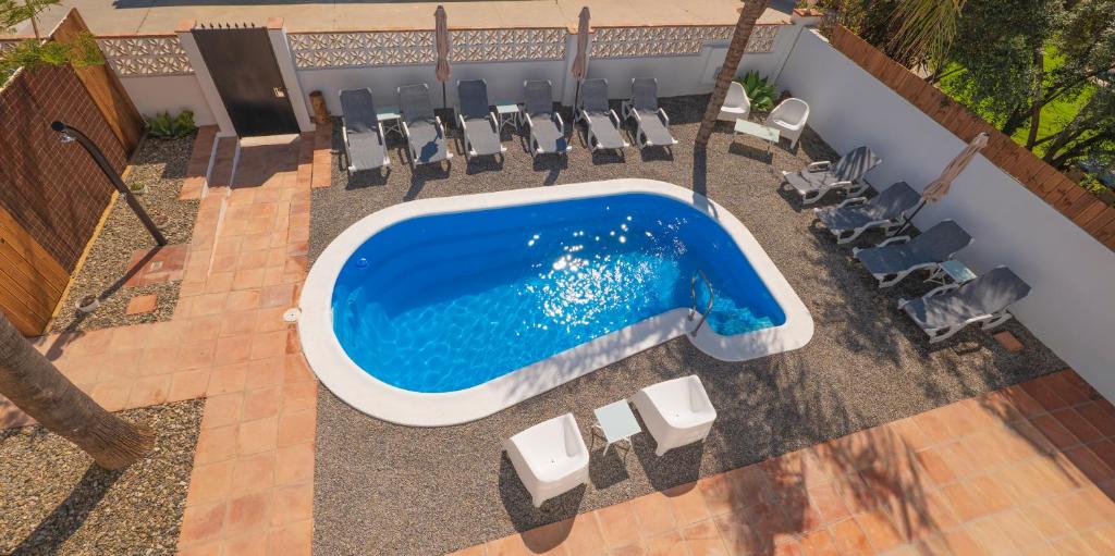 an overhead view of a swimming pool with lounge chairs and a pool at Coliving Torremolinos Casa privada in Torremolinos