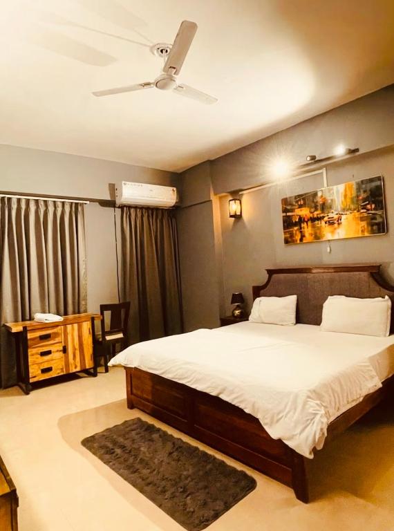 a bedroom with a bed and a ceiling fan at Skyline Serenity by Vantage View in Nalmatha