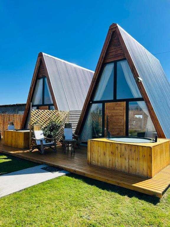 a house with a large deck with a hot tub at Andinas de Uco Lodge in La Consulta