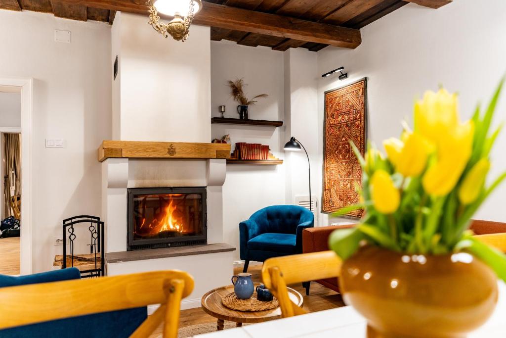 a living room with a fireplace and a vase of yellow flowers at Gabri Guesthouse Transylvania in Aita Seacă
