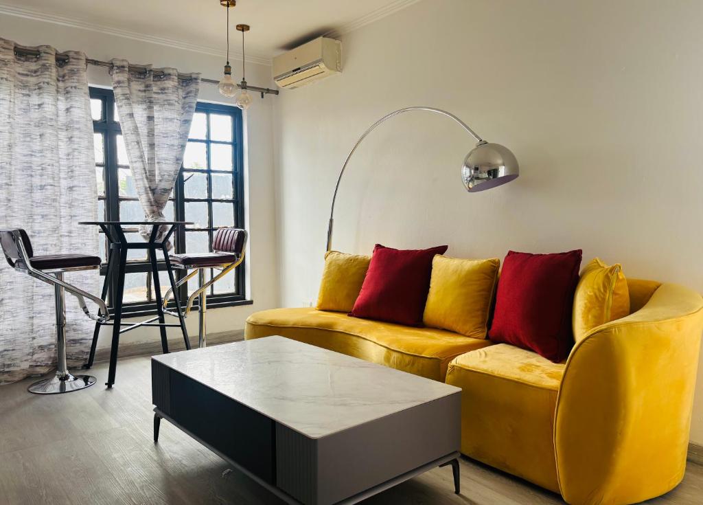 a living room with a yellow couch and a table at Austra Deluxé Villa in Windhoek