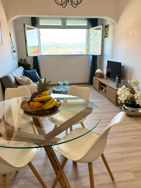 a living room with a glass table and chairs at Apartment Fortuna in Korčula