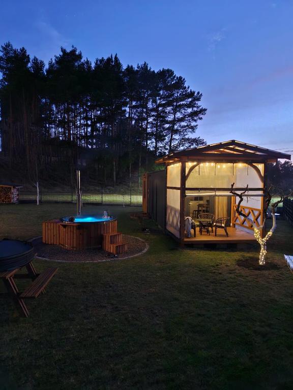 a tent in a field with a table and a pool at Święty Spokój Bielinek balia jacuzzi taras Chojna Cedynia in Cedynia