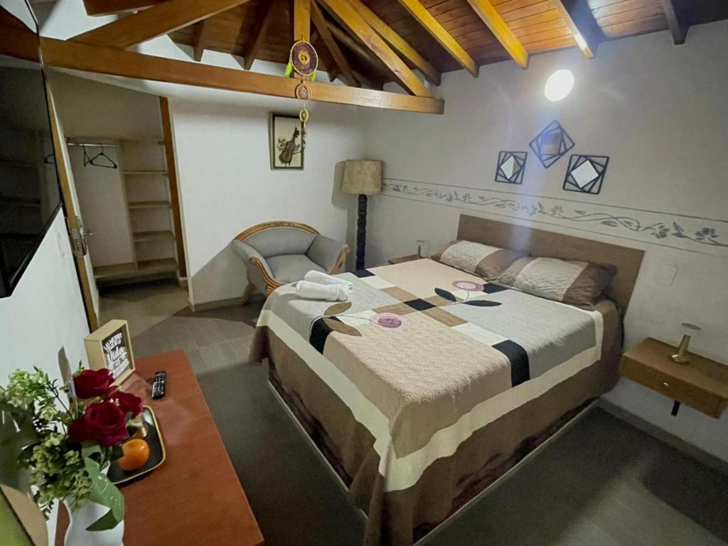 ein Schlafzimmer mit einem großen Bett und einem Tisch in der Unterkunft Hotel Olímpica in La Ceja