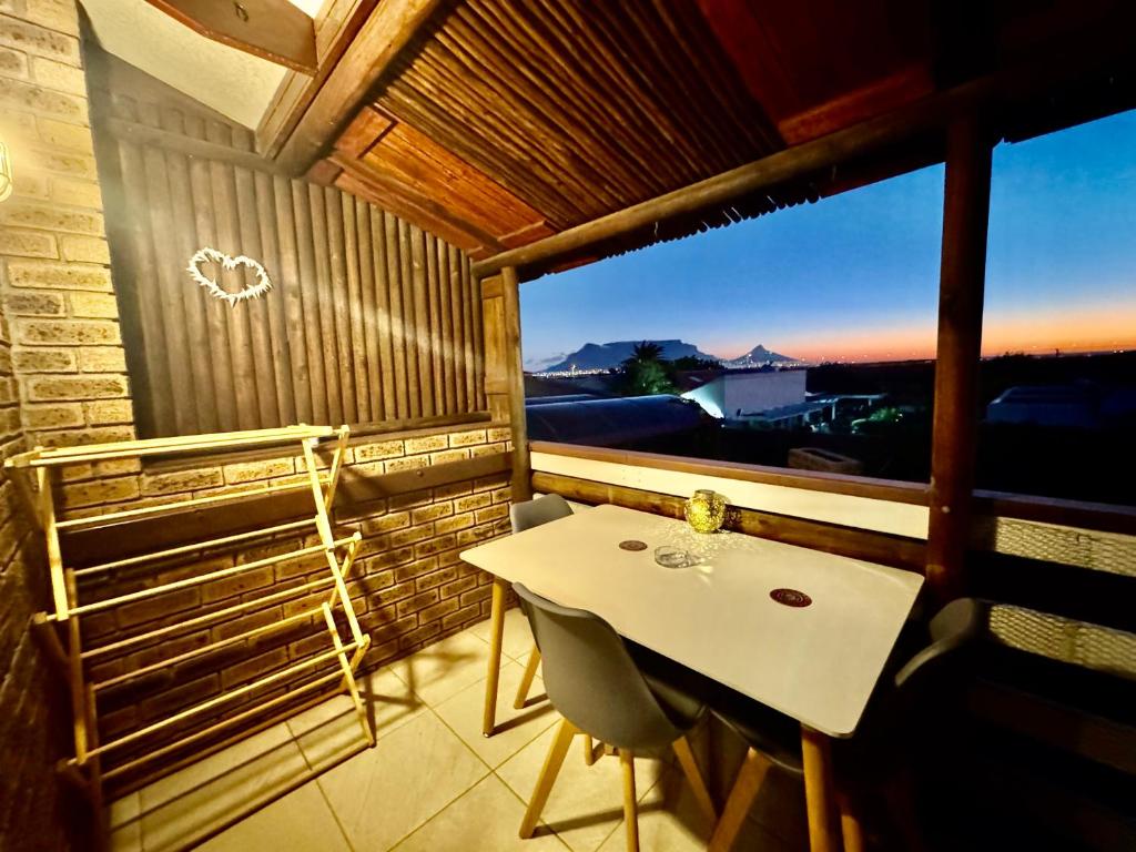a table and chairs on a balcony with a view at Egret's Lookout in Cape Town