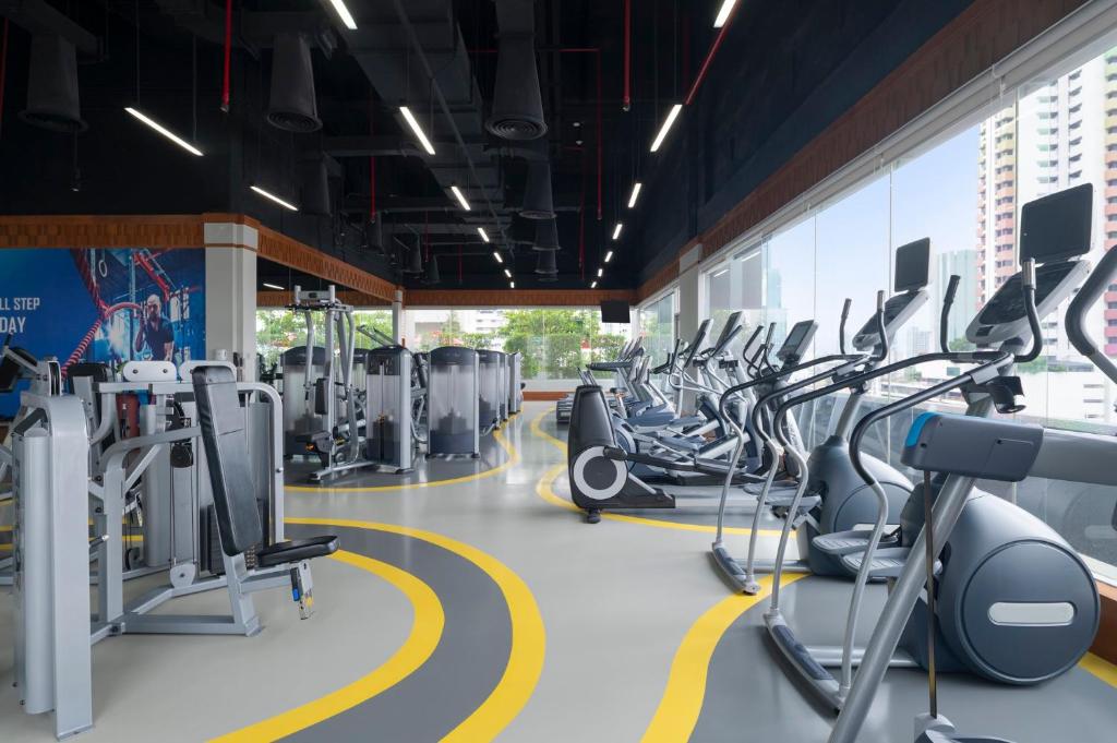 A bright, spacious fitness floor lined with cardio machines and resistance equipment.