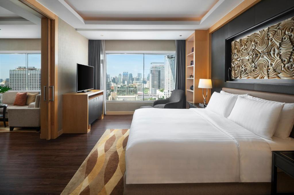 A king room with a full-height city view, television and a separate seating area.
