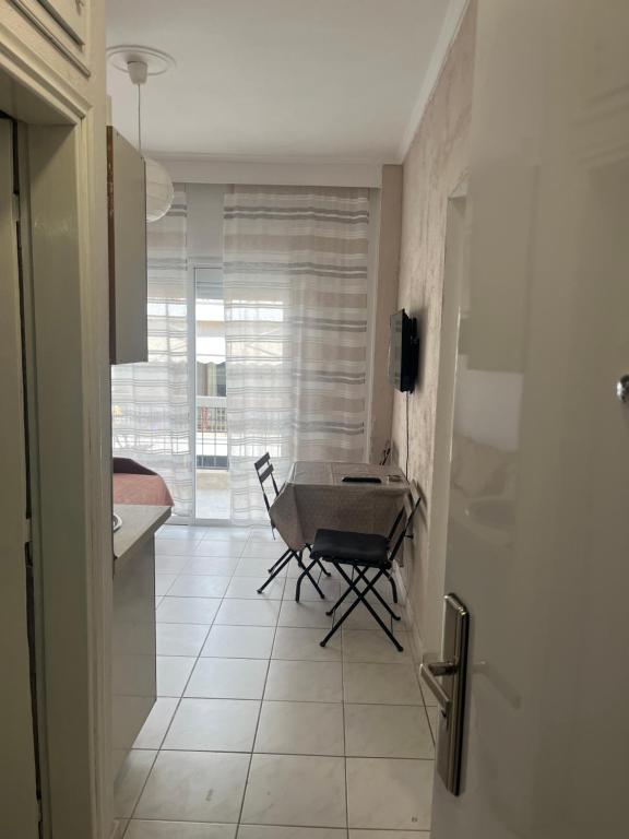 a kitchen with a table and a chair in a room at Megalou Alexandrou in Nea Moudania